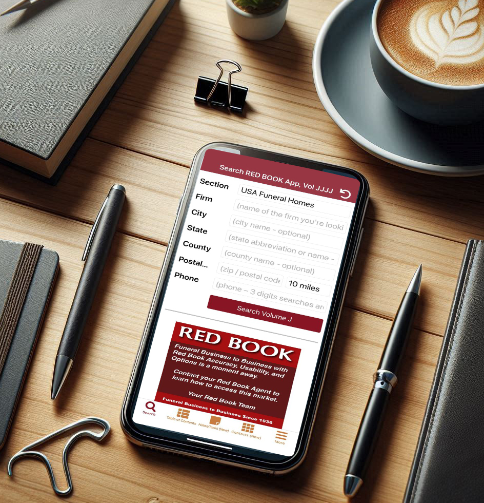 e-RED BOOK mobile app on a desk with coffee and notebook